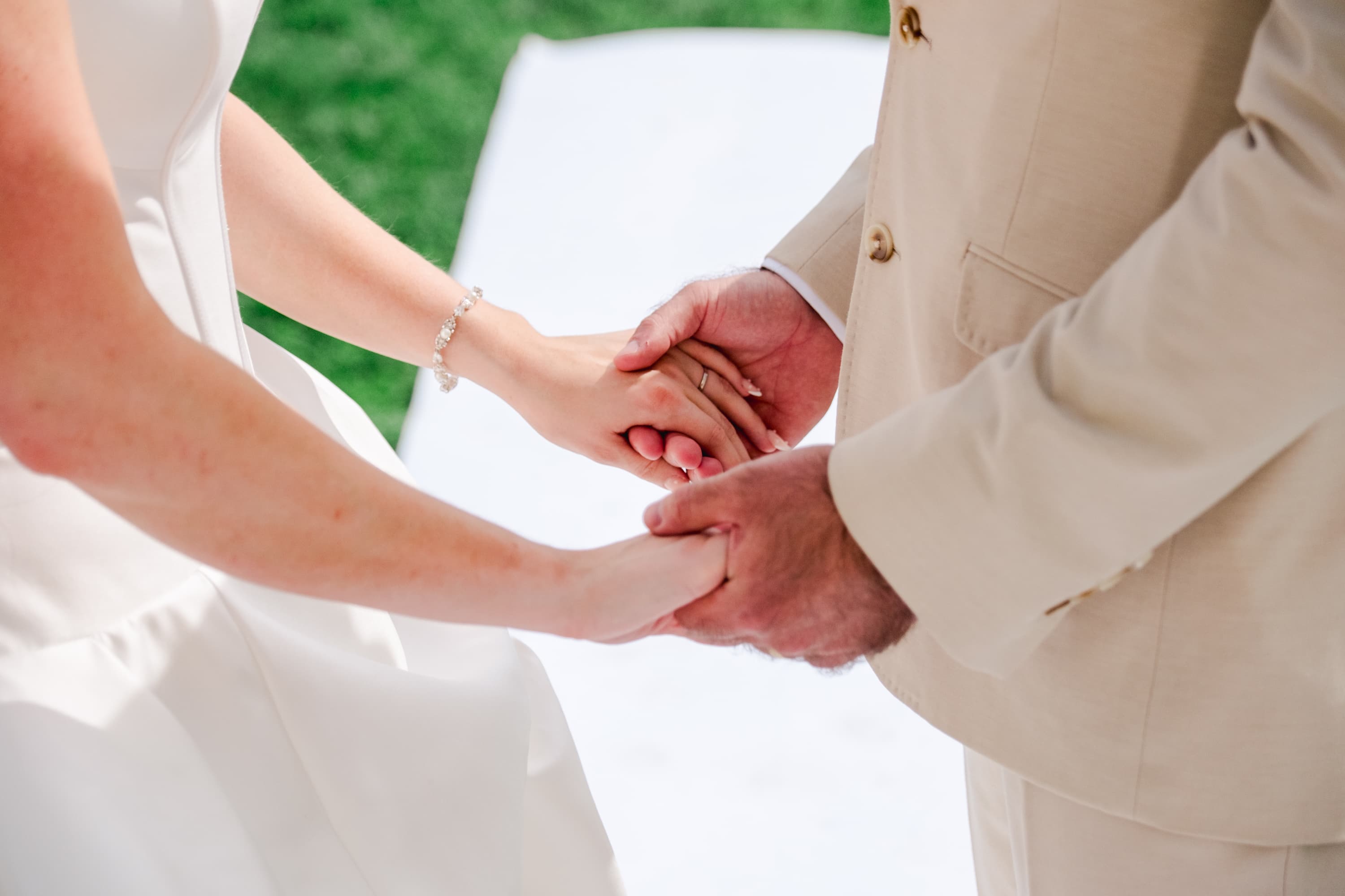 Mariés Chloé et Bradley se tenant les mains lors de la cérémonie laïque au Chateau Fengari