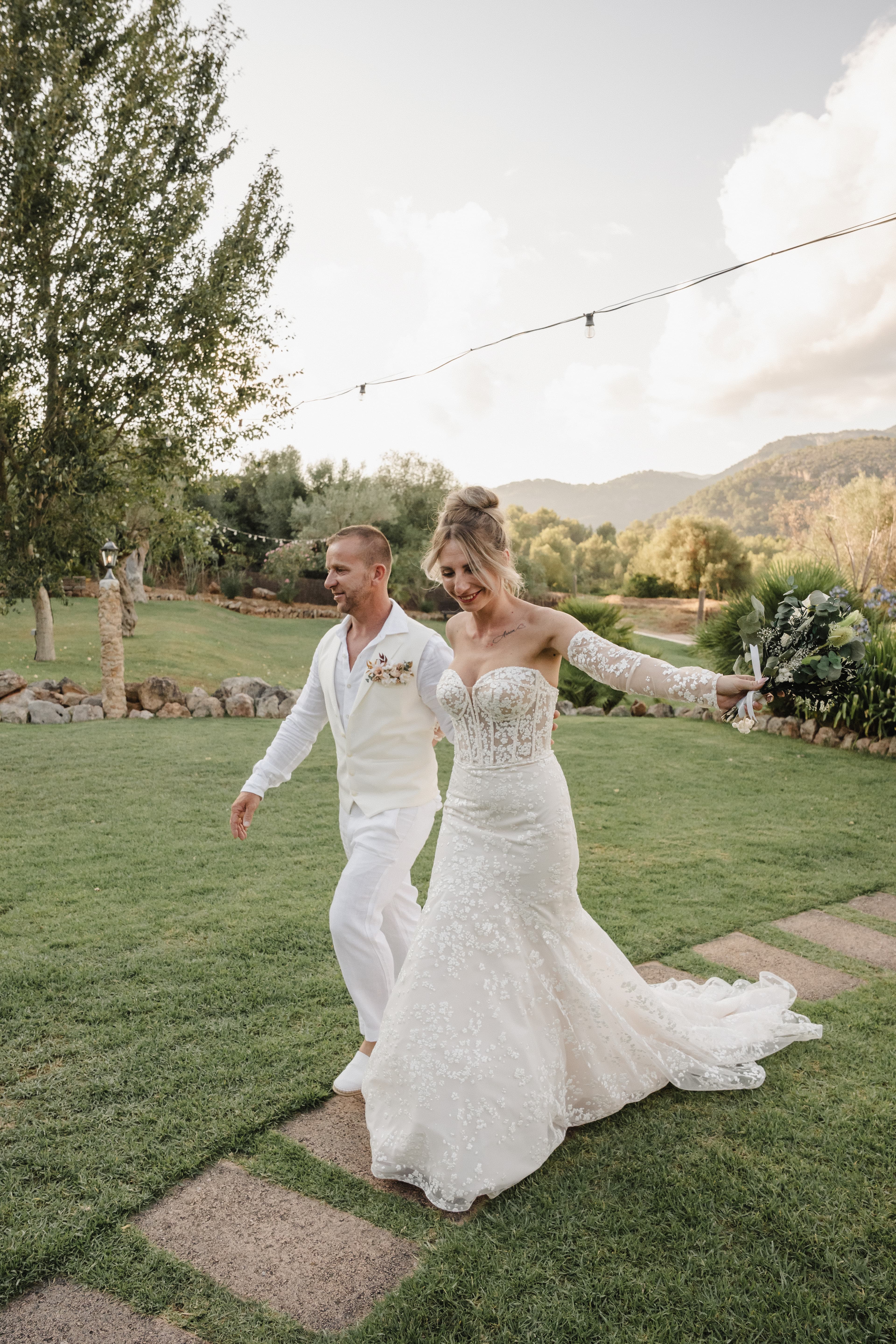 mariés cristina et bruno marchant dans les jardins fleuris du domaine à palma de majorque