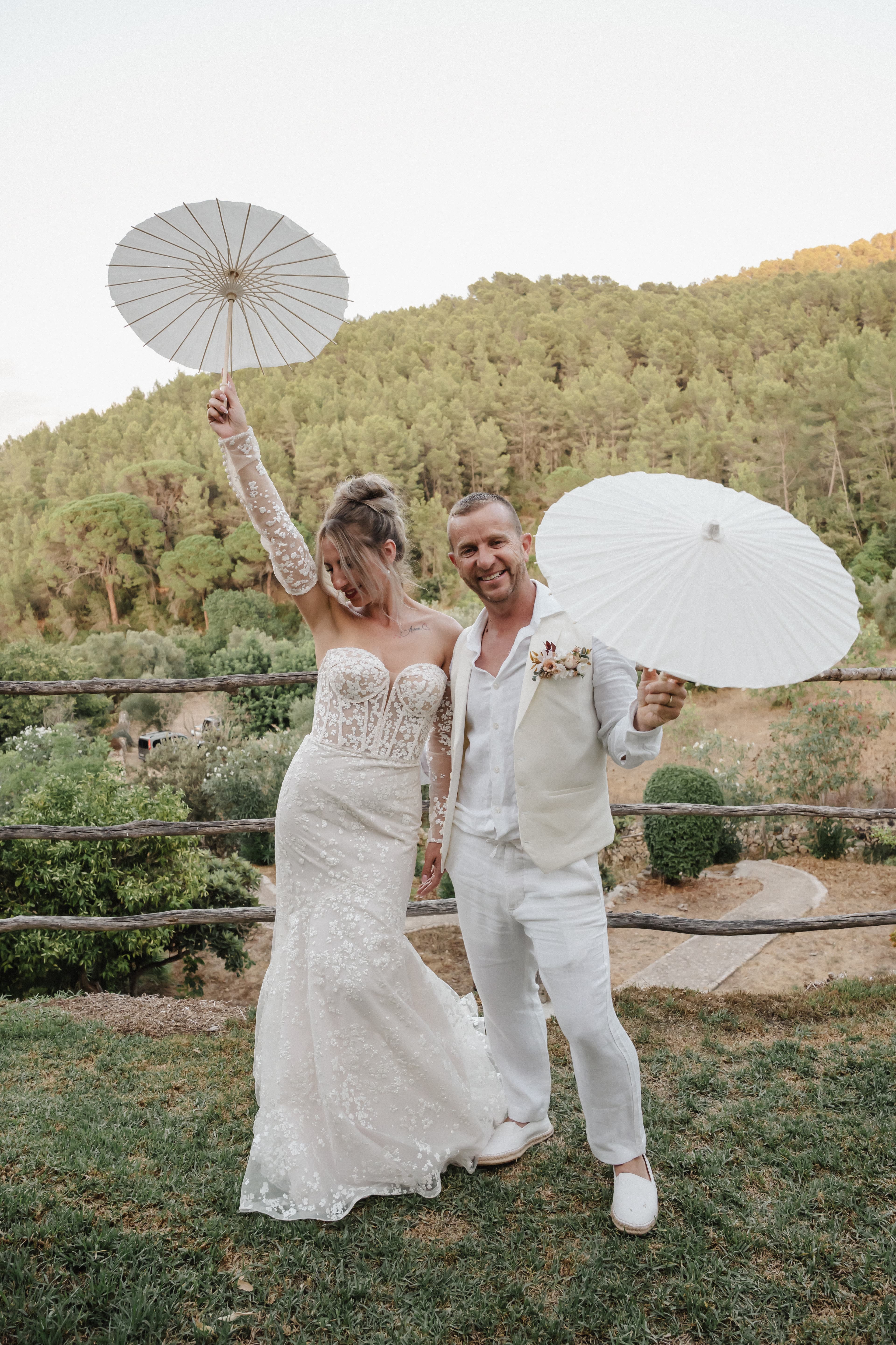 mariés cristina et bruno pose fun avec des ombrelles dans les jardins du domaine à palma de majorque