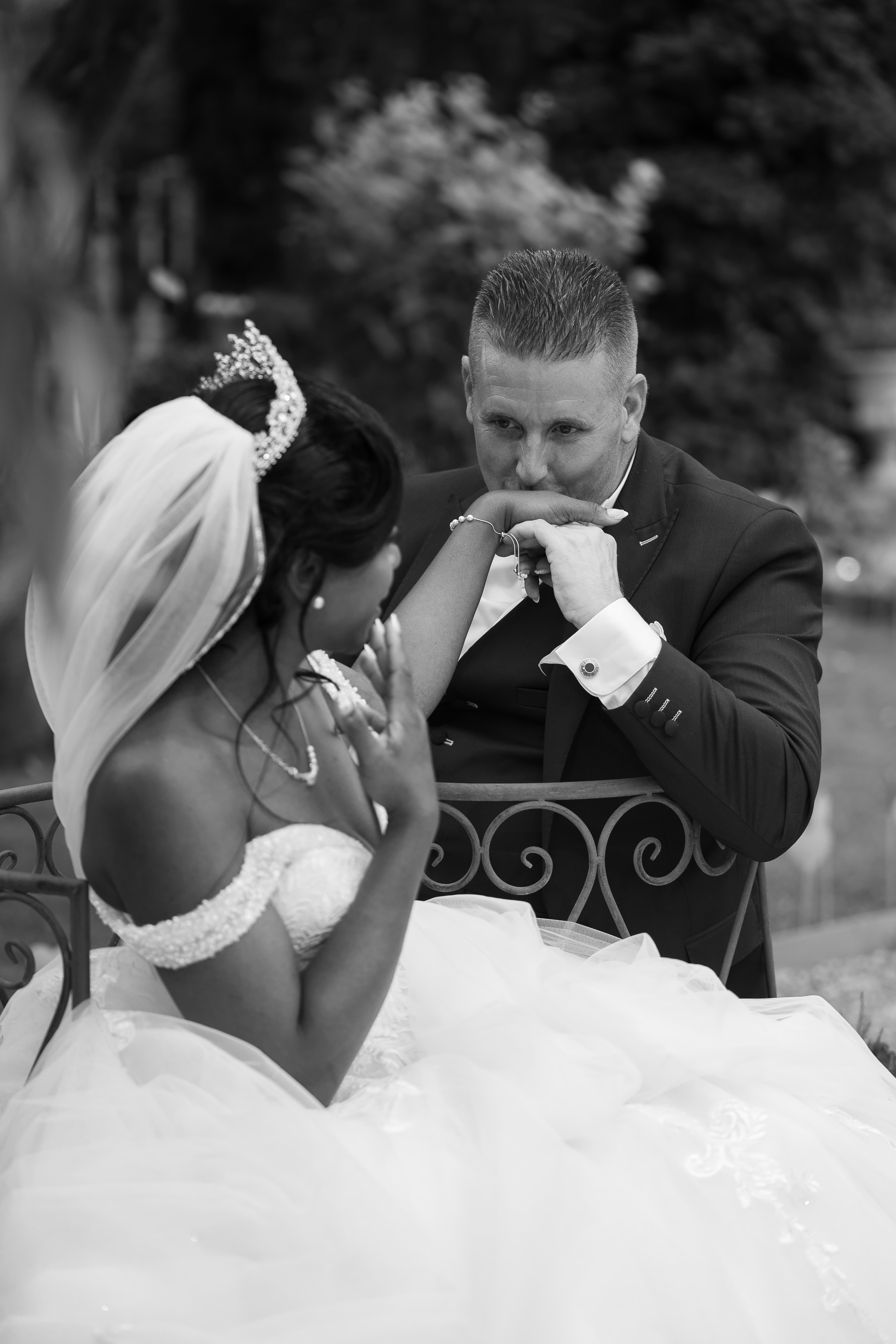 mariés elodie et joann portrait en noir et blanc sur un banc dans le jardin du domaine des vergers du roy
