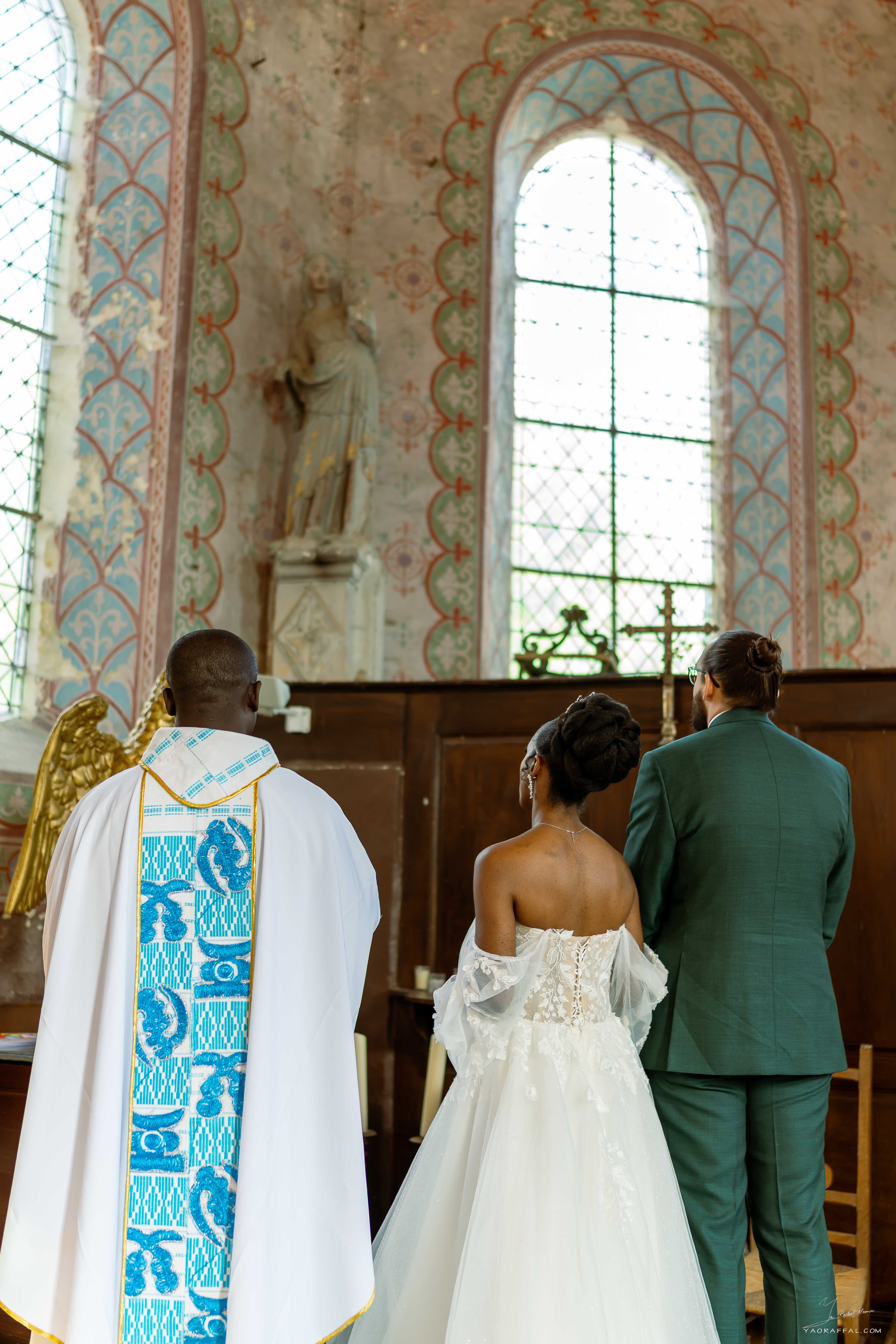 mariés gisèle et thomas avec le prêtre lors de la cérémonie religieuse à l'église