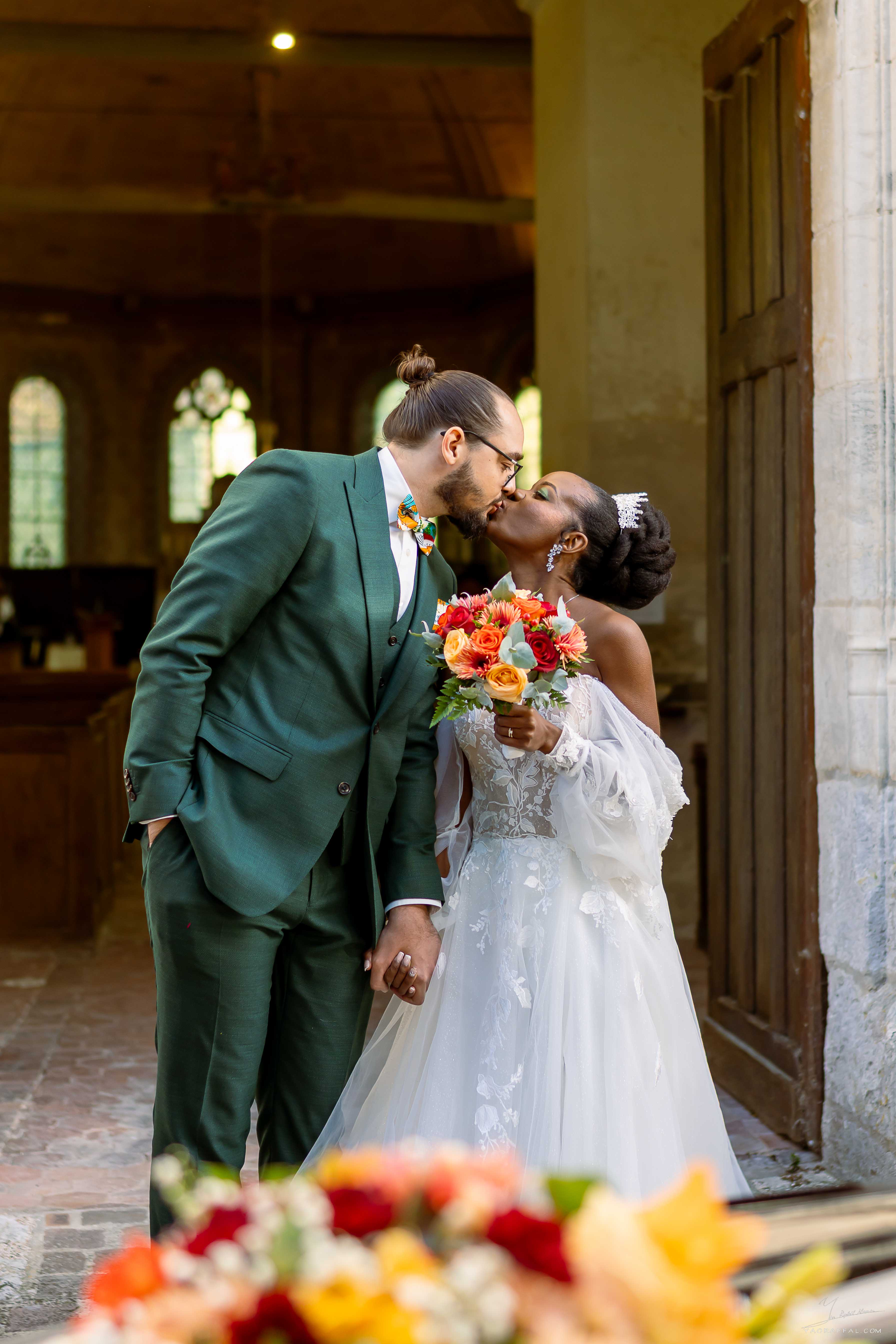 mariés gisèle et thomas s'embrassent à la sortie de l'église