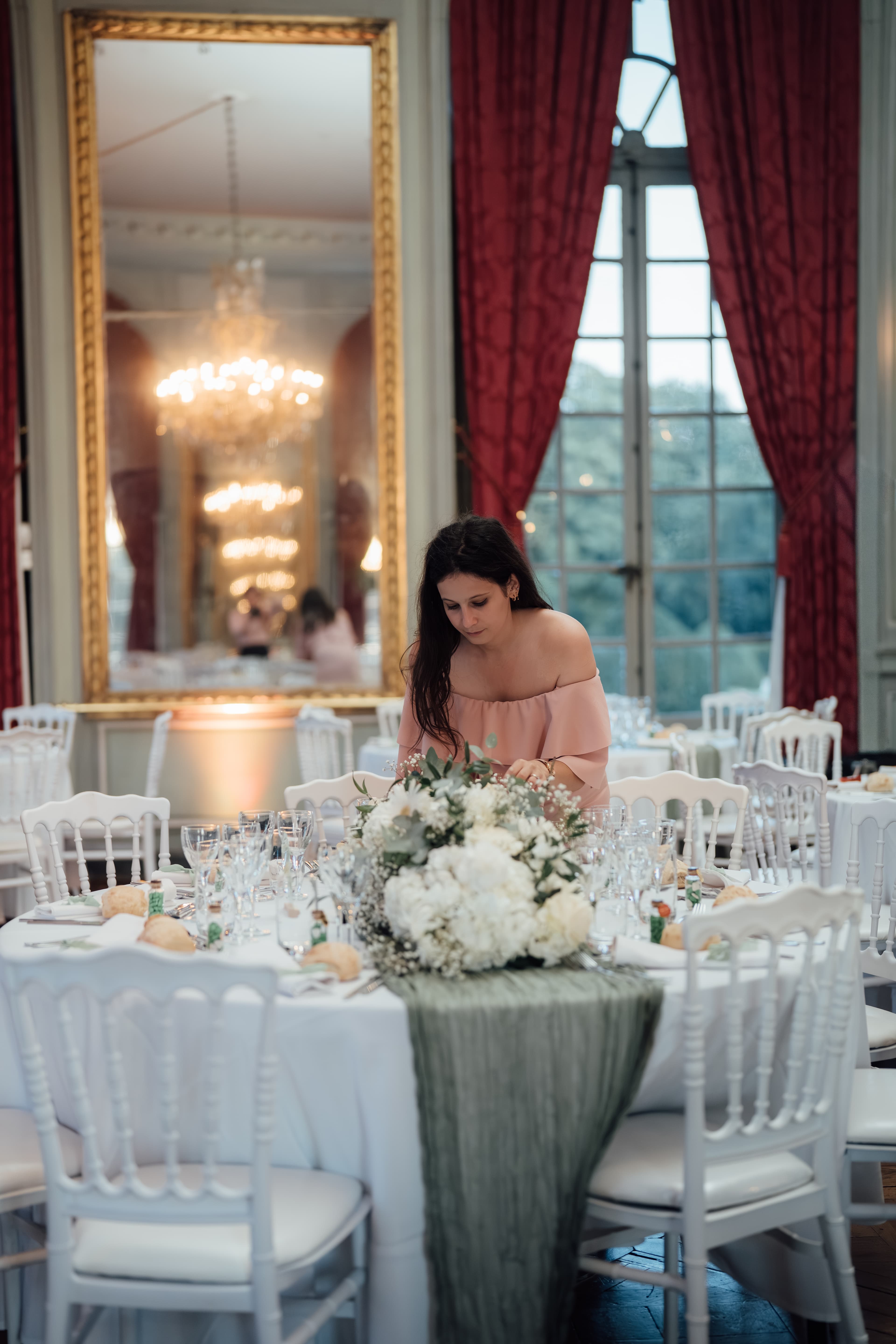 mariés marine et maxime retouche décoration des tables par la wedding planner au château de champlatreux