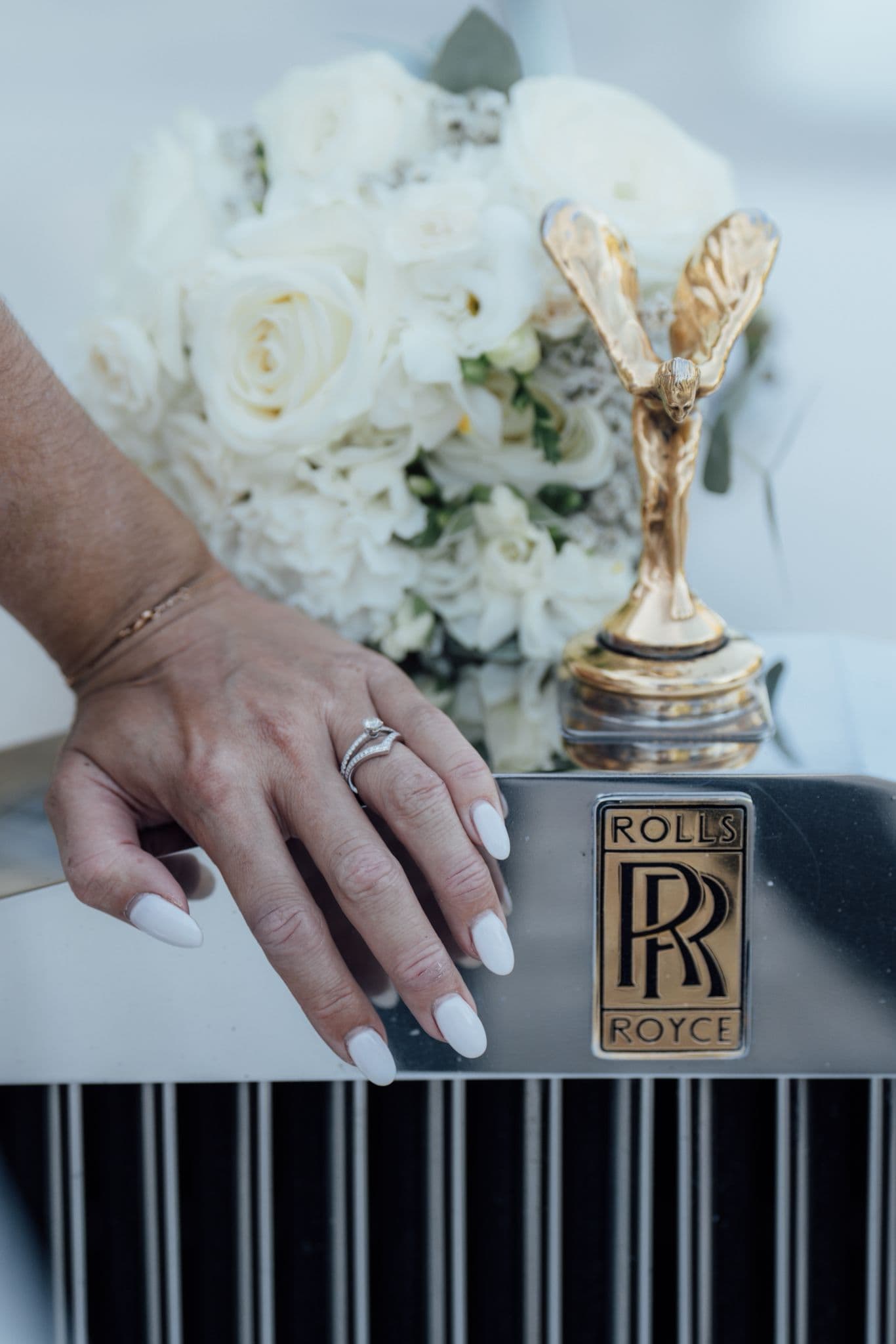 mariée marine posant sa main sur la rolls royce devant le château de champlatreux