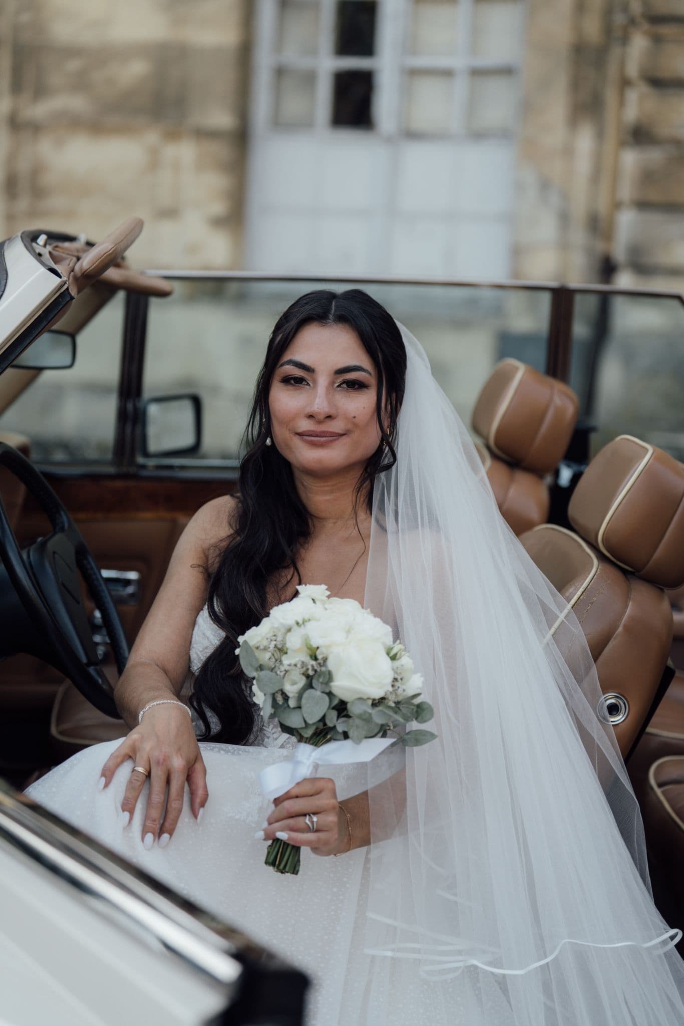 mariée marine posant dans la rolls royce devant le château de champlatreux