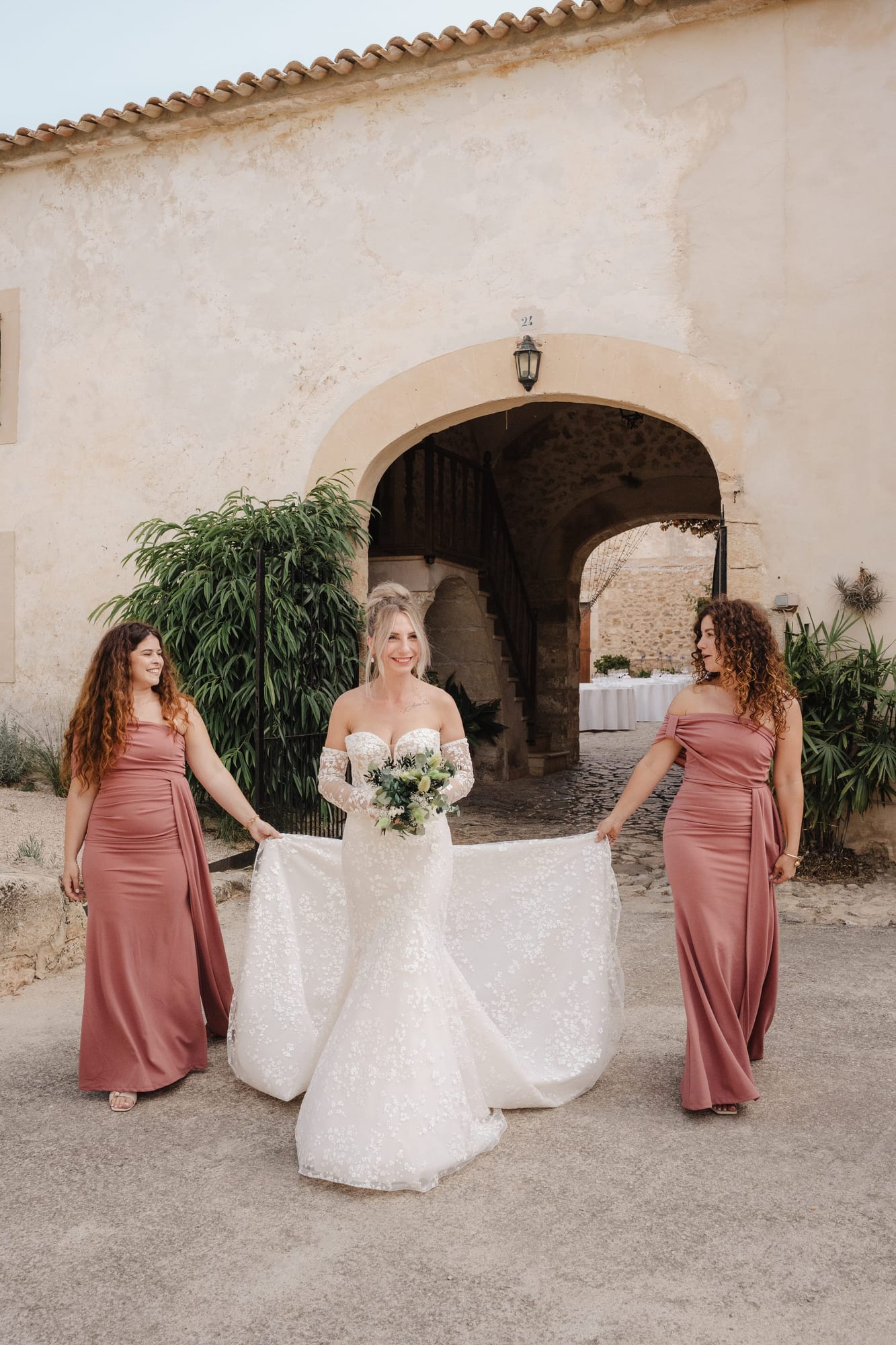 mariée cristina accompagnée de ses demoiselles d'honneur tenant sa robe de mariée à palma de majorque