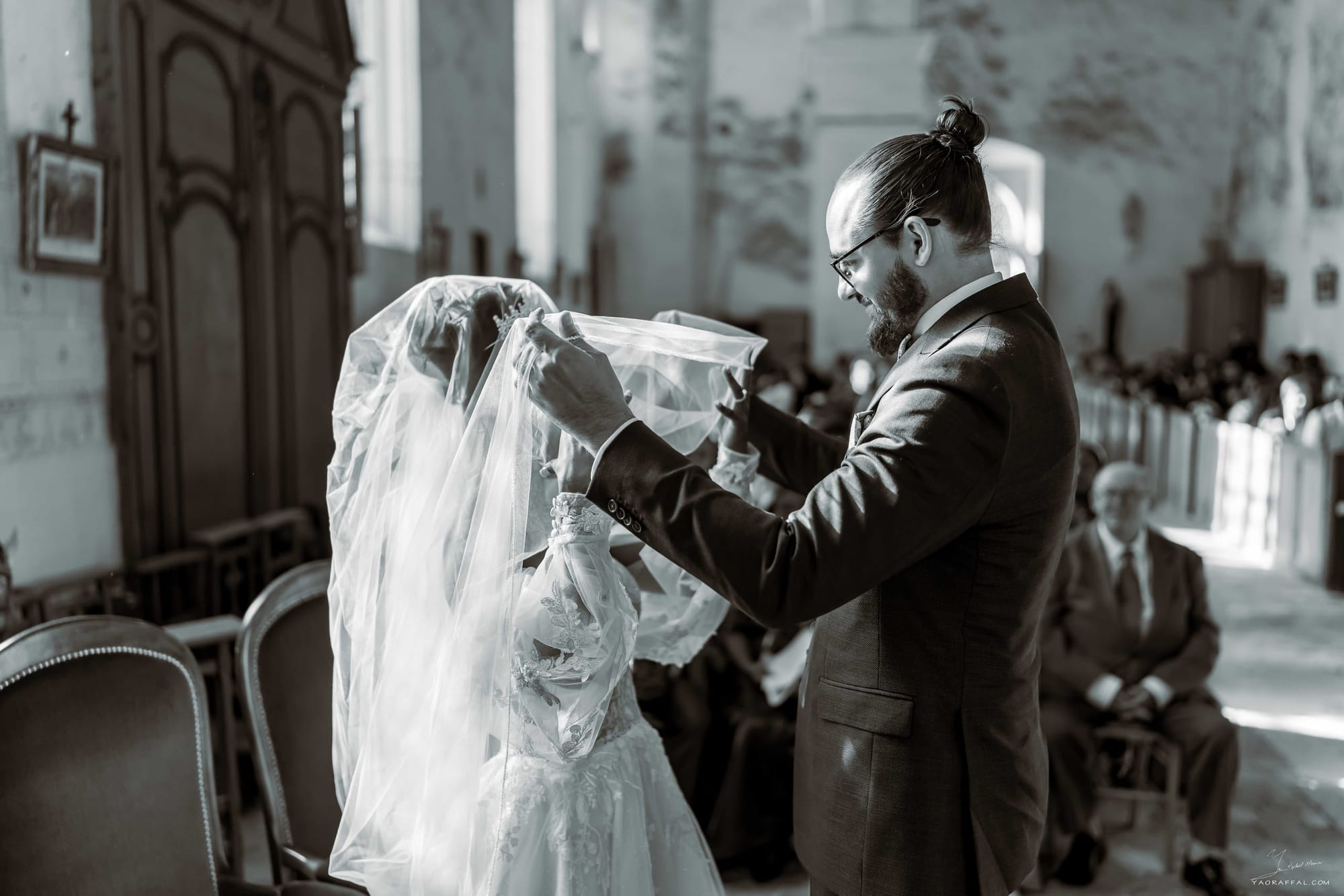 marié thomas retire le voile de la mariée lors de la cérémonie religieuse à l'église