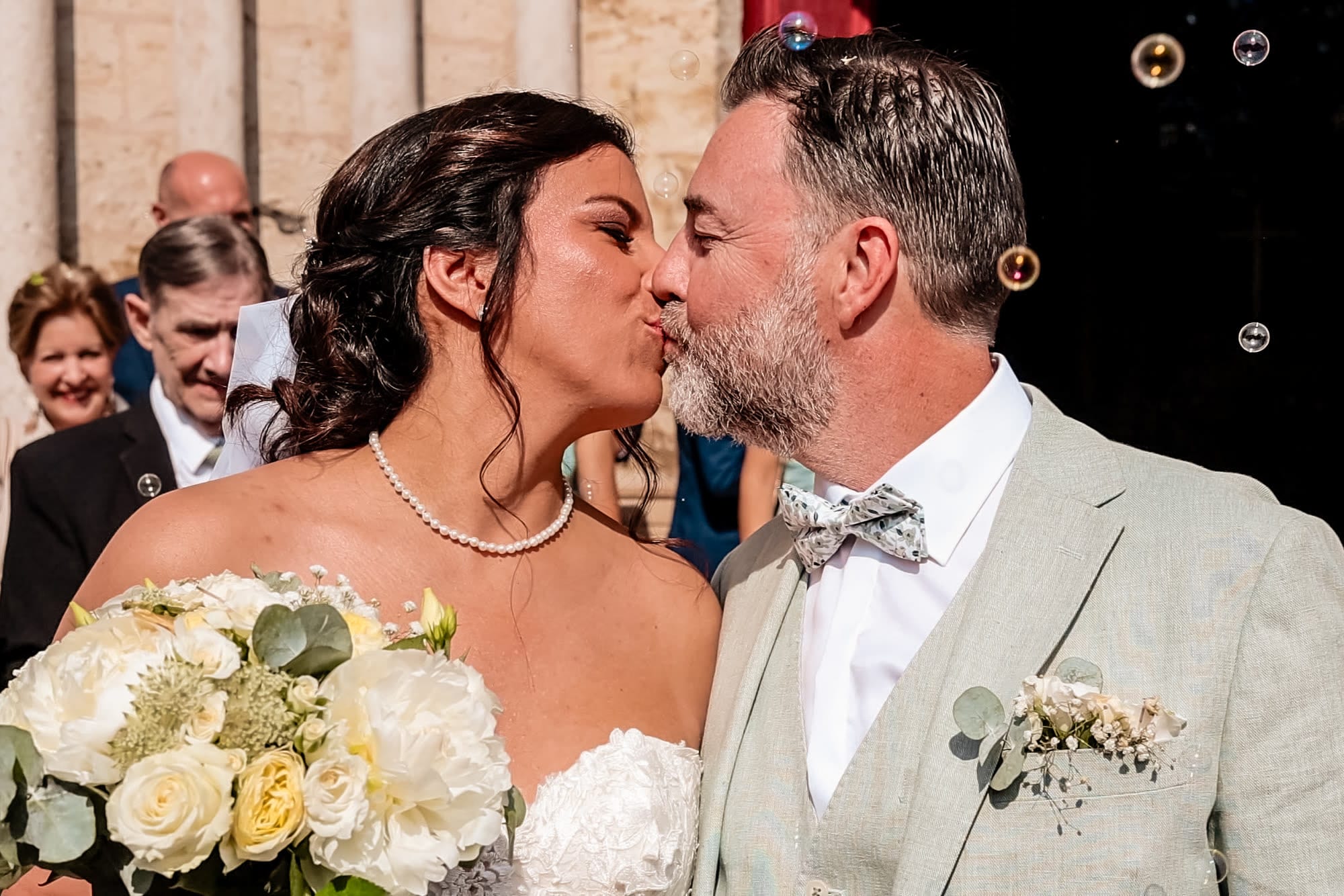 mariés marie et frédéric premier baiser sous les bulles de savon à la sortie de l'église