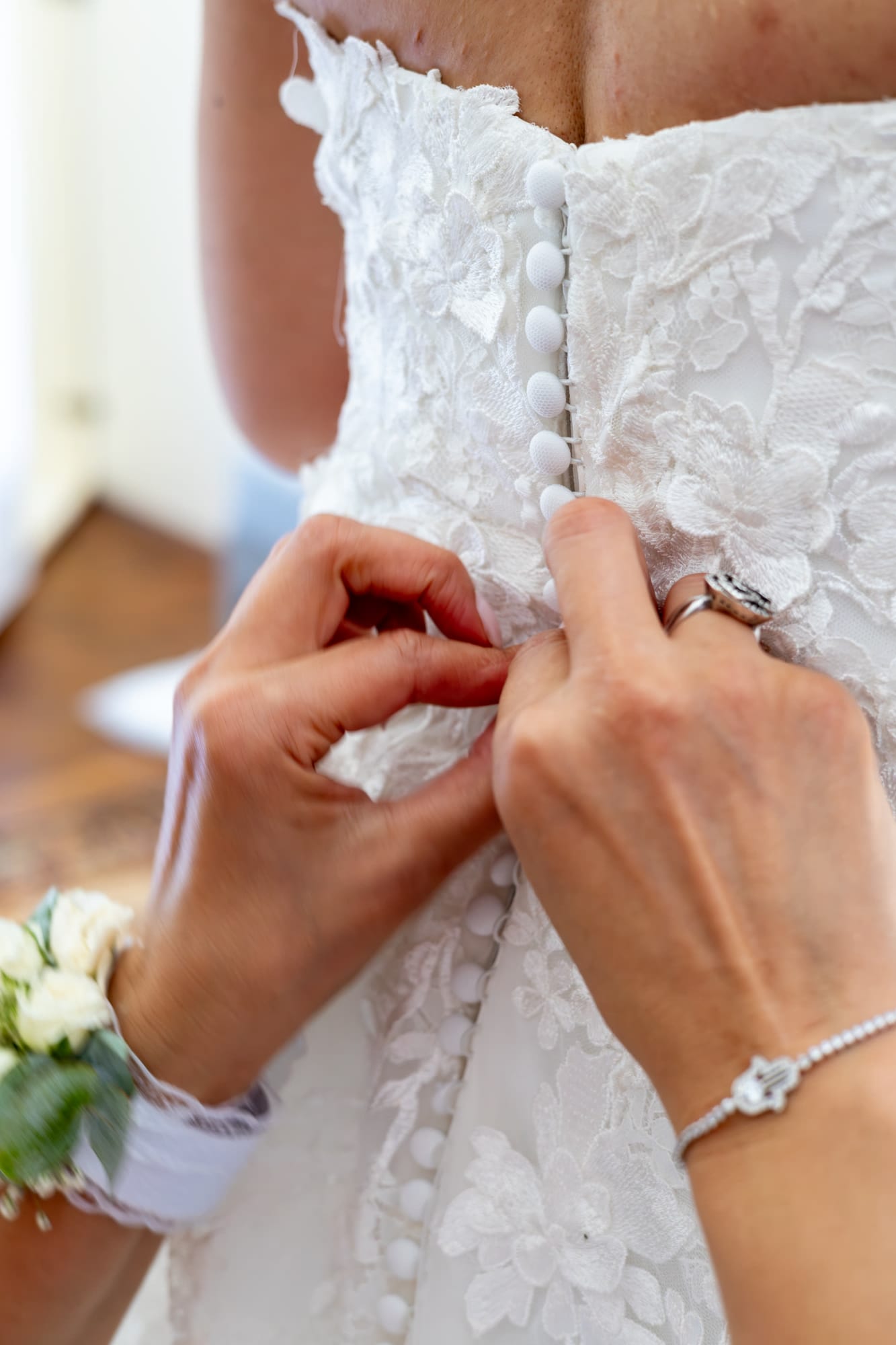 mariée marie boutonnage de la robe de mariée en dentelle lors des préparatifs au château d'avesnes le castelet