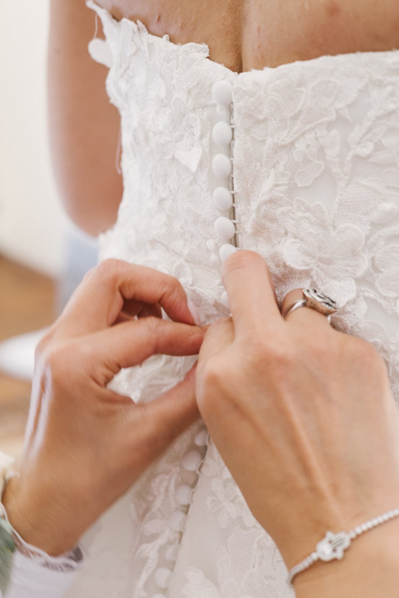 mariée marie détail des boutons de la robe de mariée en dentelle au château d'avesnes le castelet
