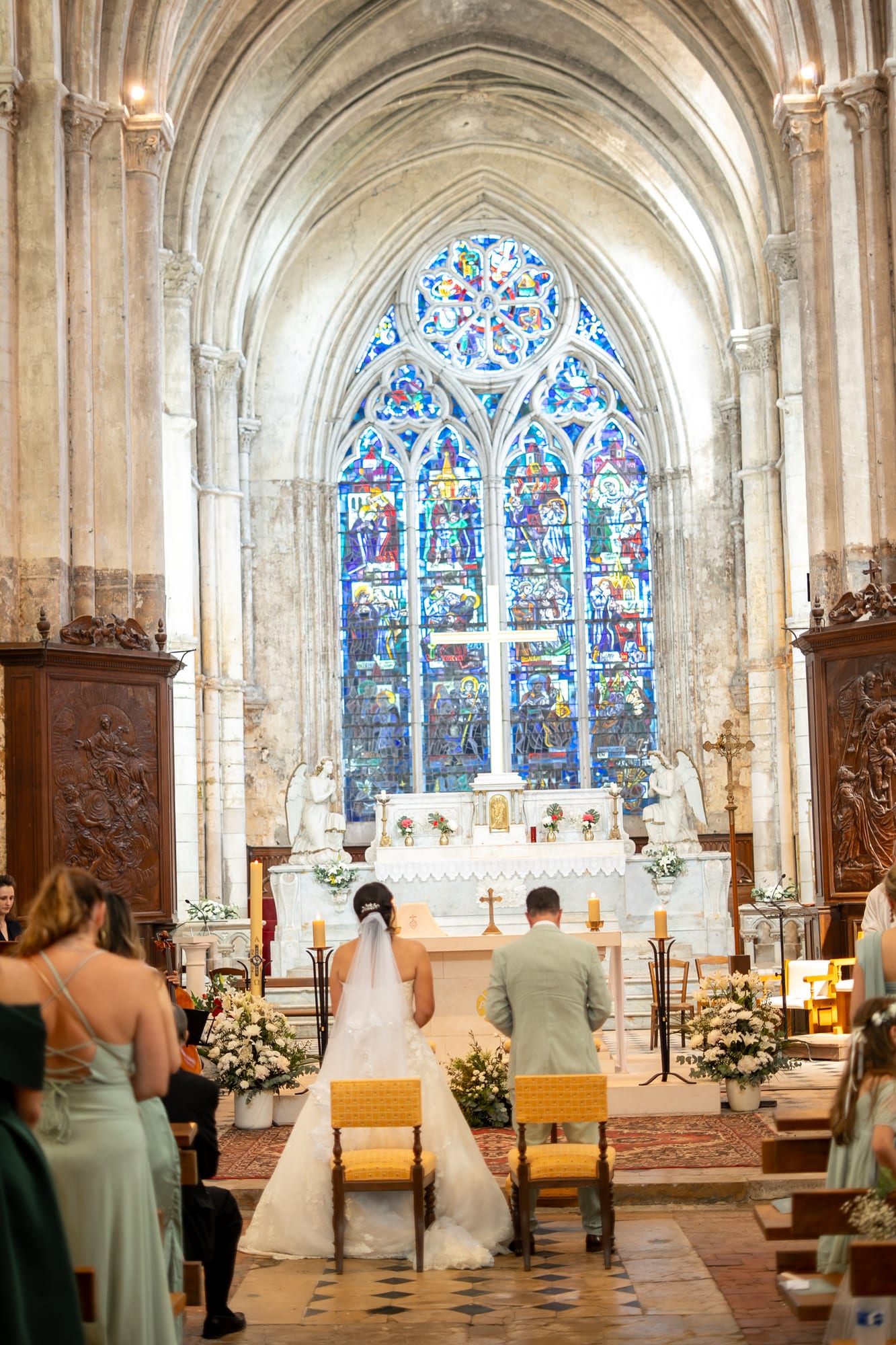 mariés marie et frédéric vue d'ensemble de la cérémonie religieuse devant les vitraux de l'église