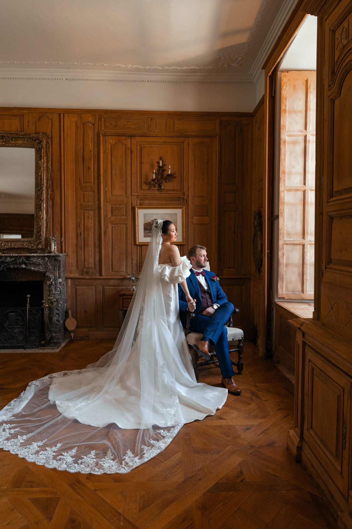 mariés yixiao et sean portrait dans le salon boisé, traîne et voile déployés