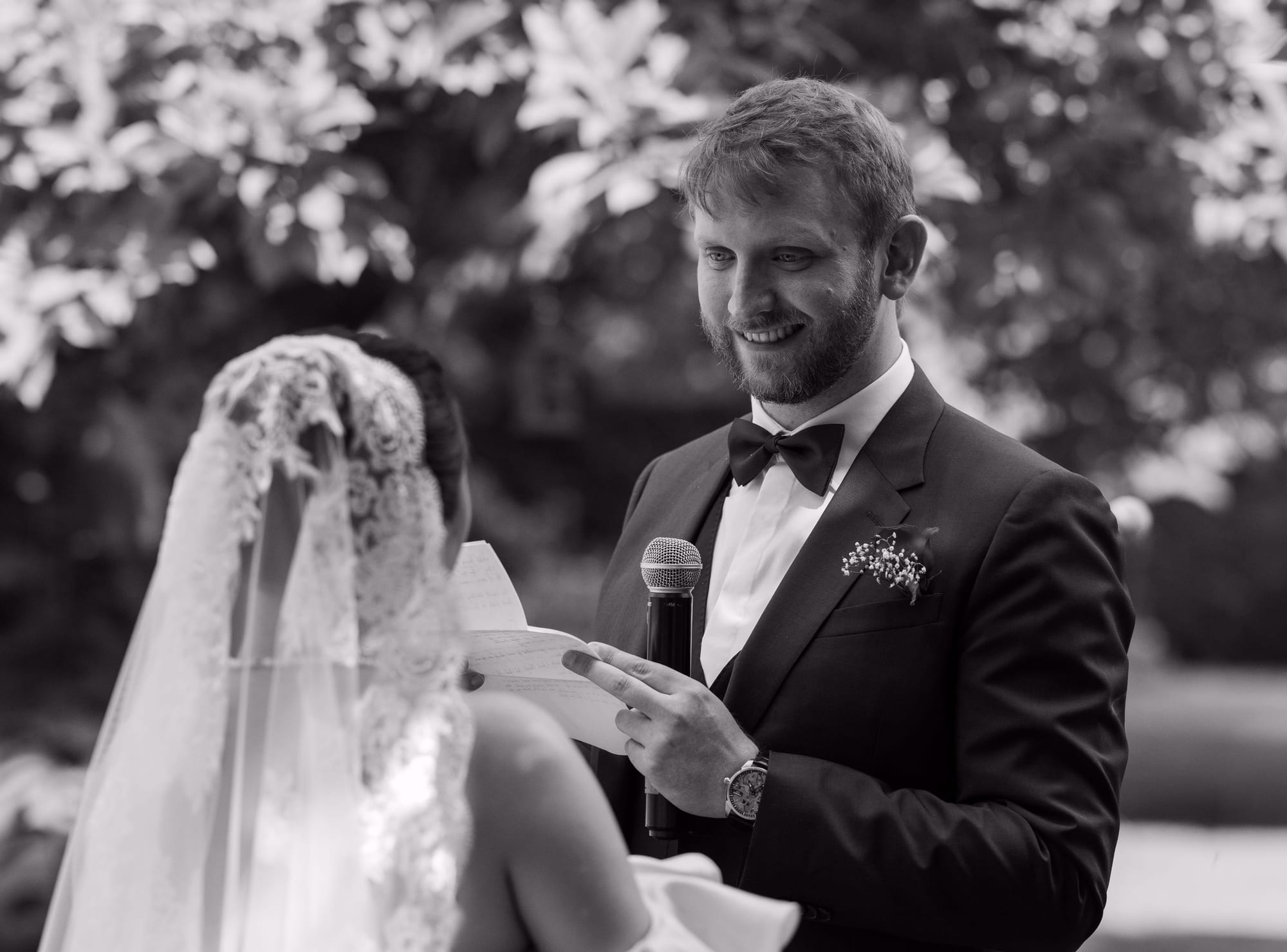 marié sean lit ses vœux à la mariée en noir et blanc lors de la cérémonie laïque