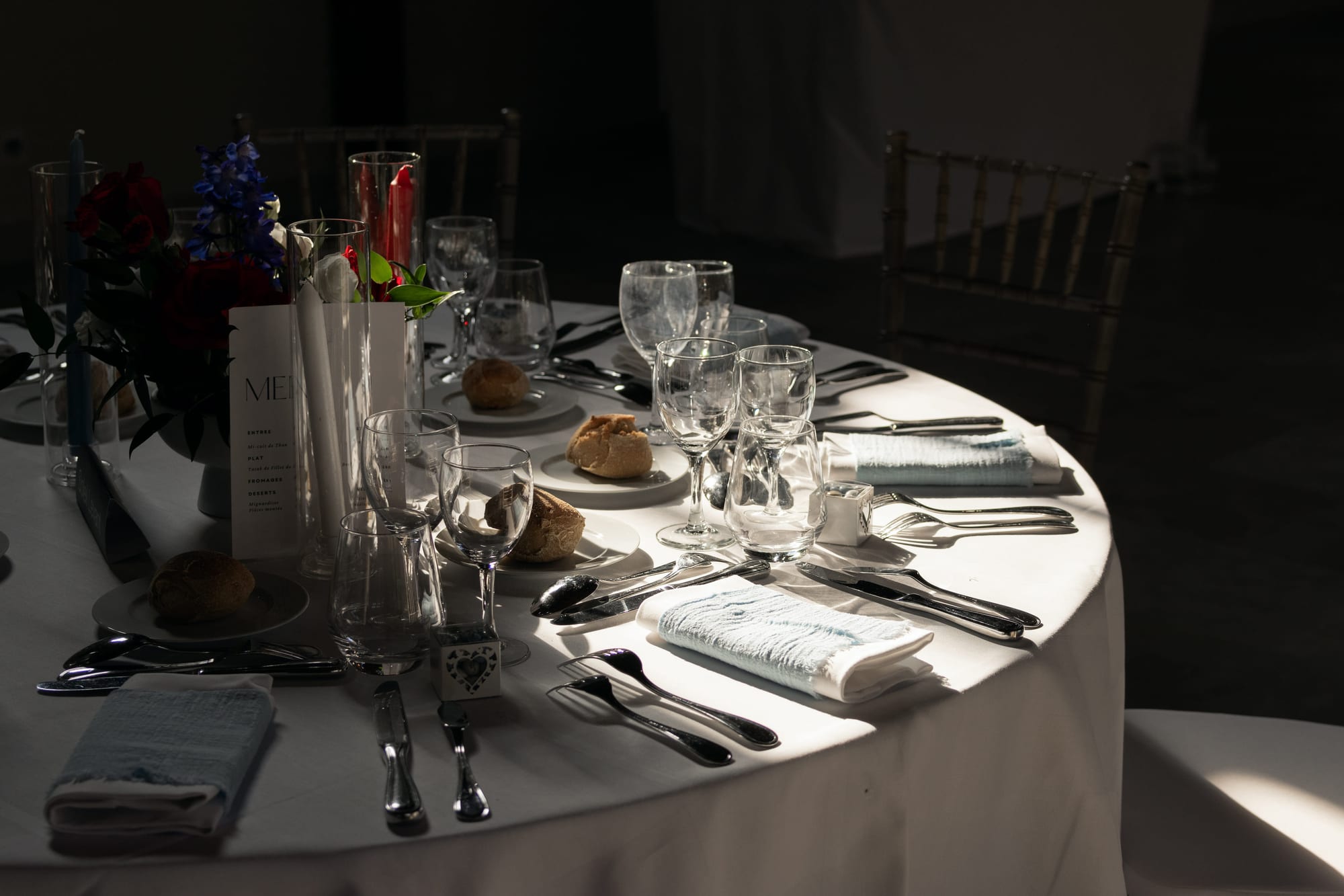 table dressée du dîner de mariage, menu et couverts dans la lumière du soir