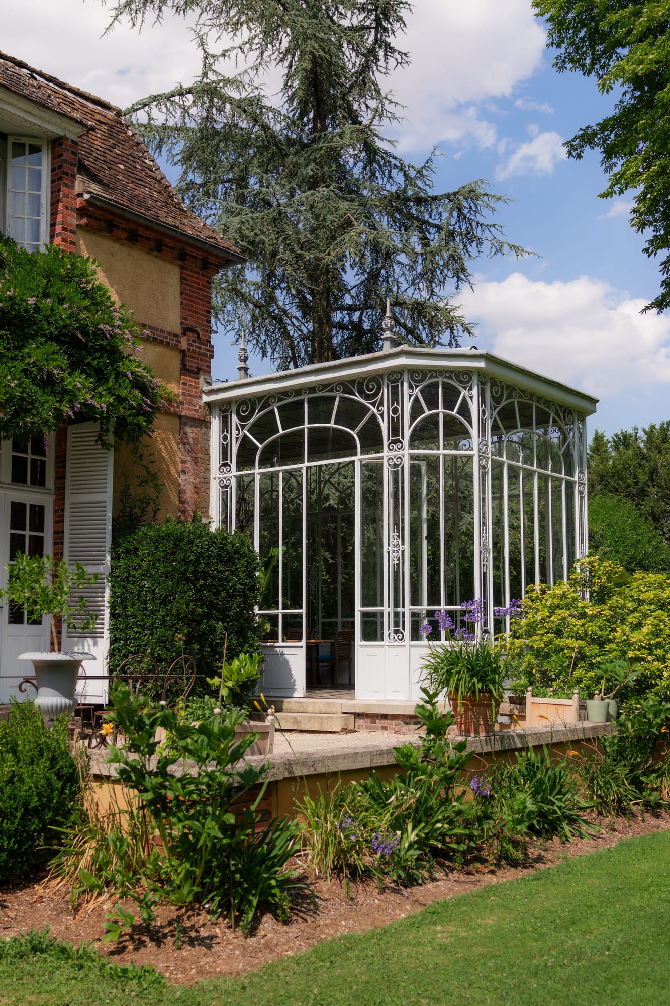 orangerie en verrière blanche dans le parc des jardins du grand courtoiseau