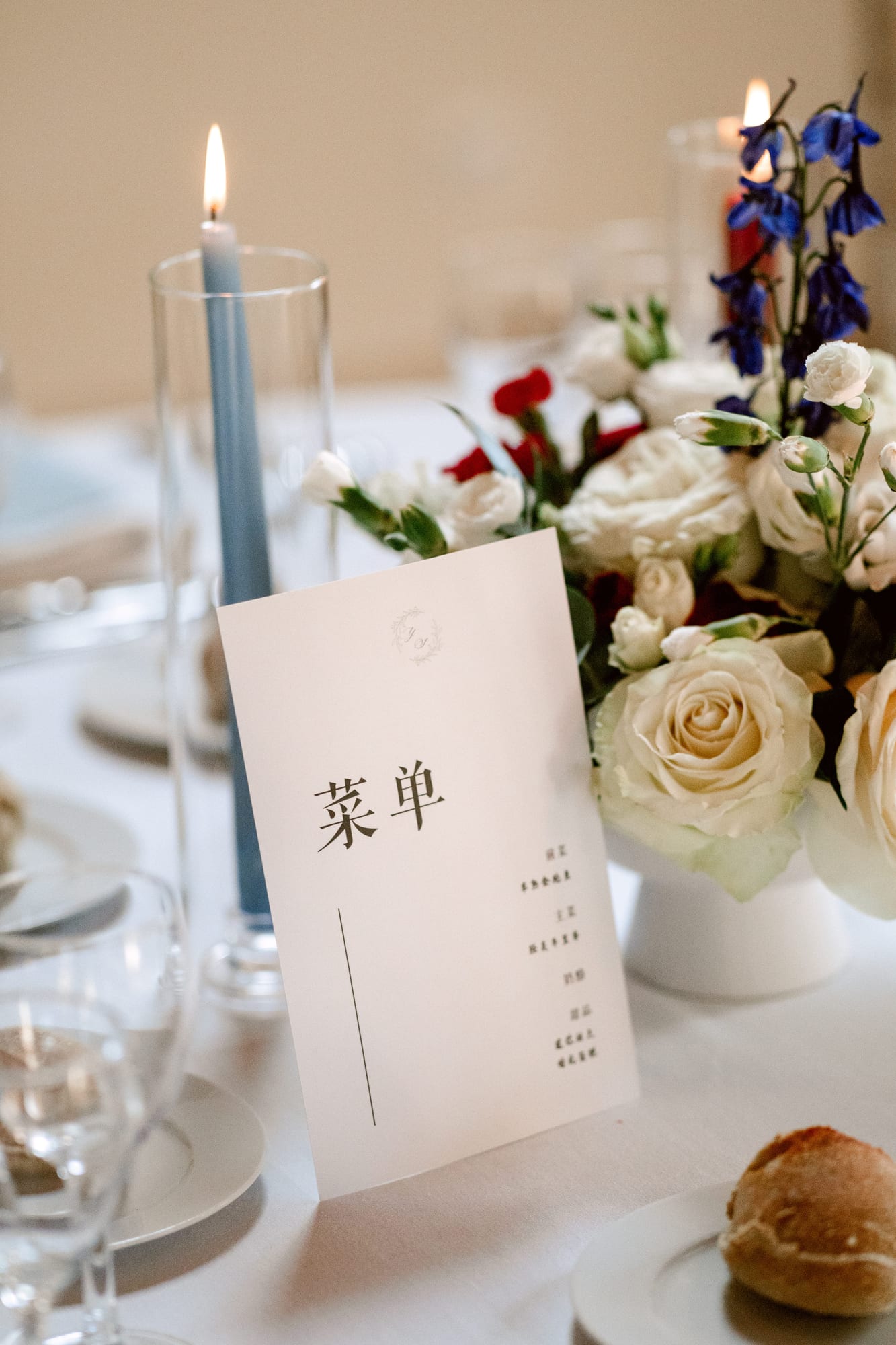 menu de mariage bilingue en chinois posé près des bougies et des fleurs