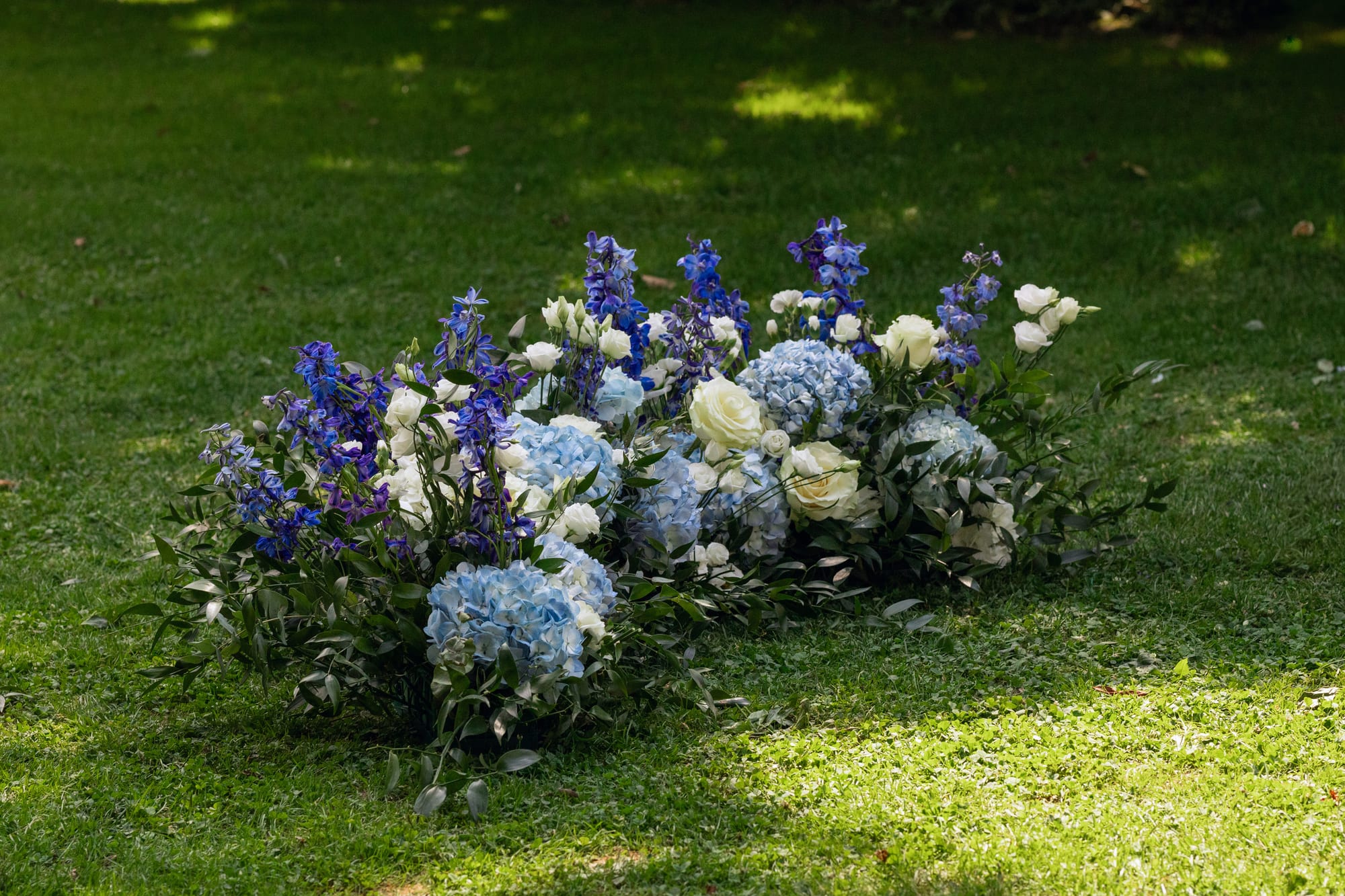 décor floral au sol en hortensias, delphiniums et roses blanches aux jardins du grand courtoiseau
