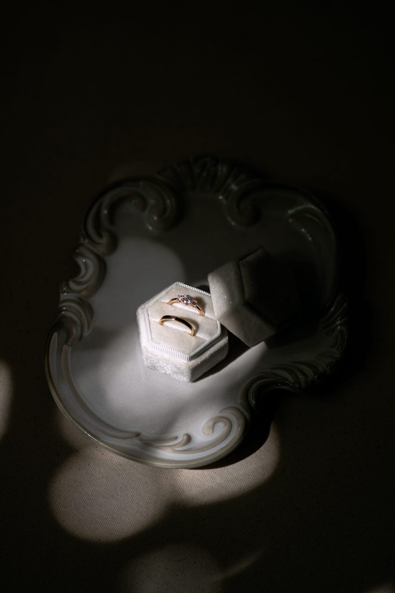 mariés yixiao et sean alliances posées sur un vide-poche en porcelaine lors des préparatifs